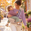 Maman qui porte son enfant sur le porte-bébé siège de hanche Cocooni Carry